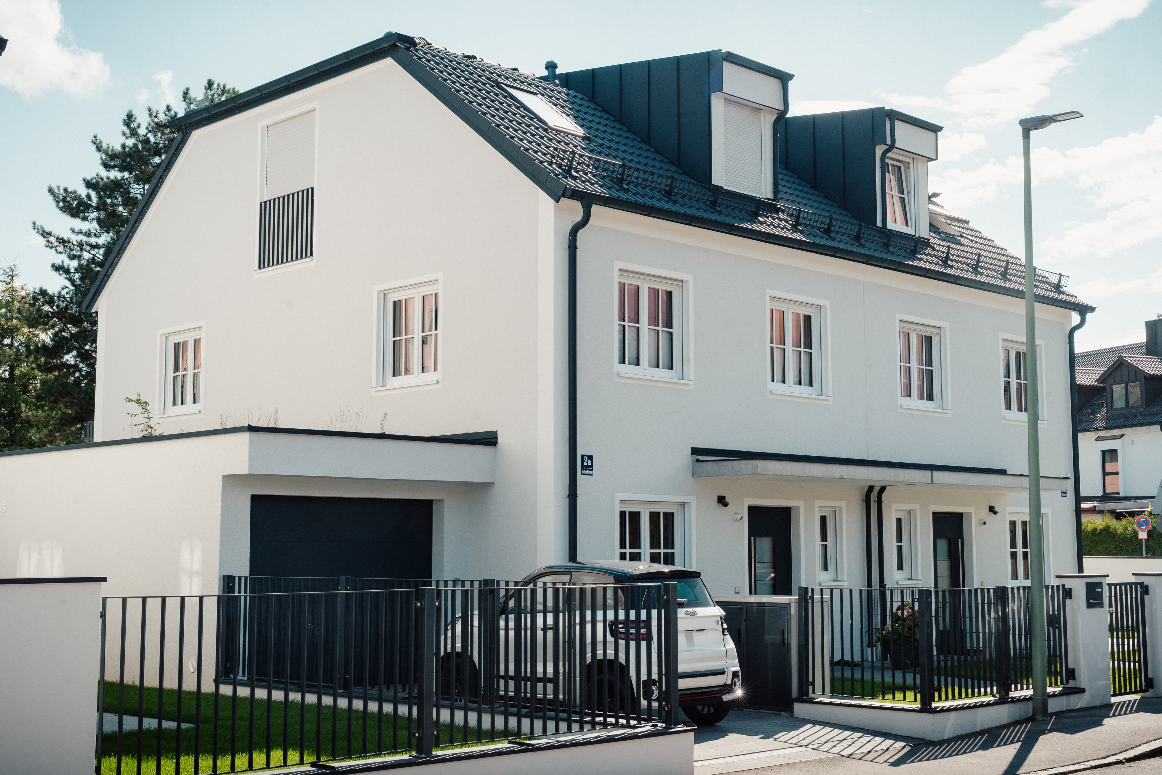 Hoferichterweg 2, 2a & 2b – Stadthaus mit heller Fassade, Dachgauben, Garage und Vorgartenzaun (Straßenansicht)