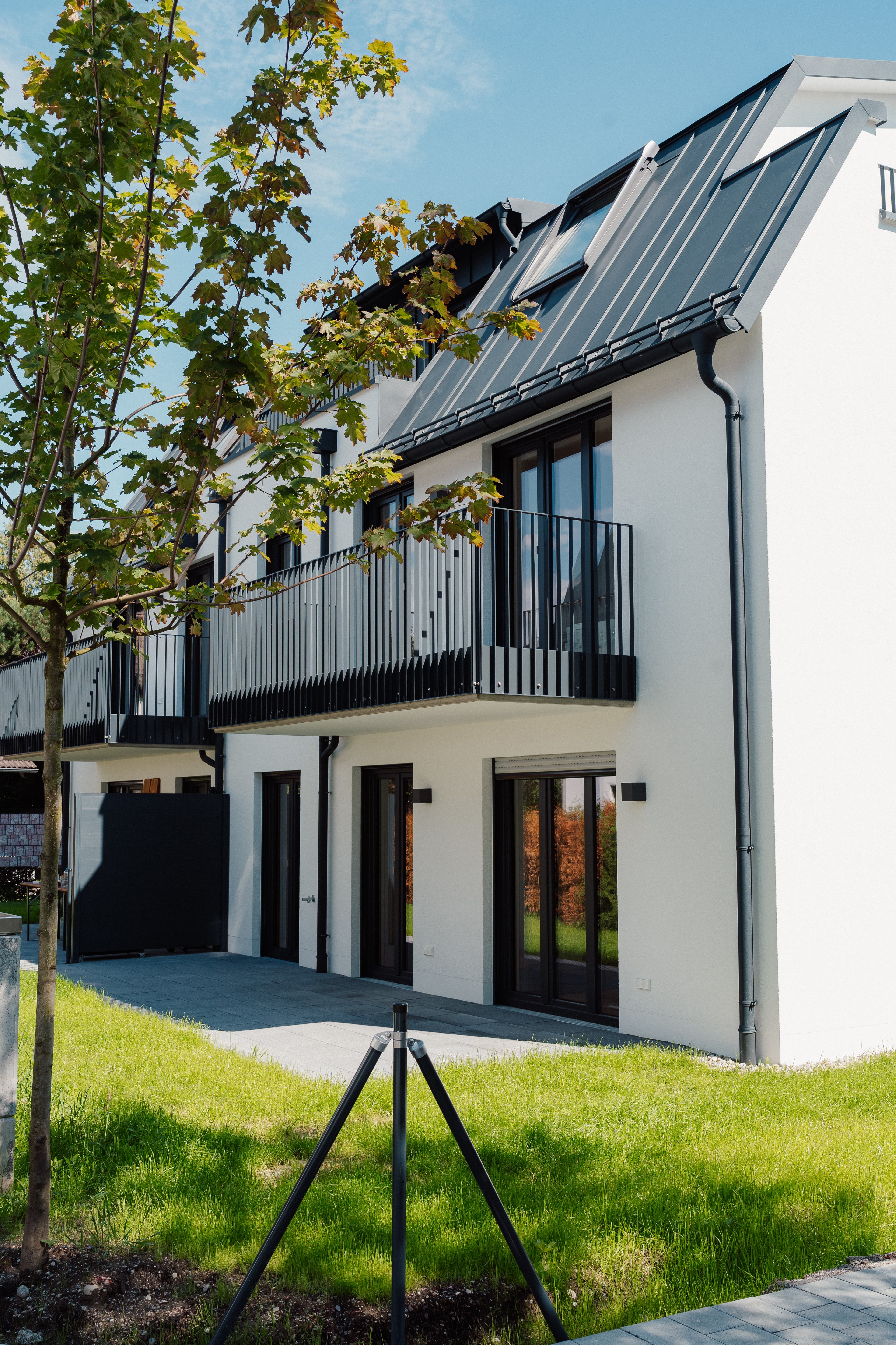 Reihenhausanlage mit Balkonen und Garagen – Straßenansicht